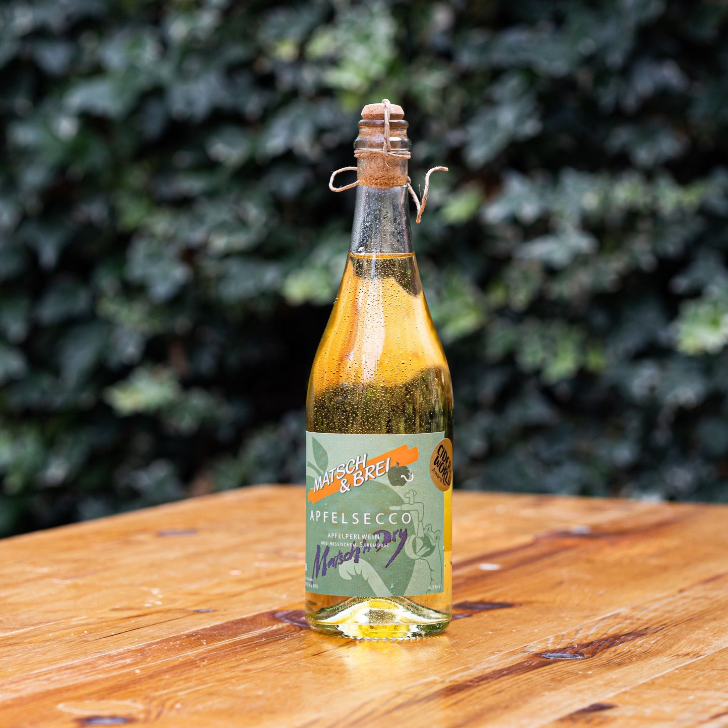 Gekühlte Matsch & Brei Apfelseccoflasche auf einem Tisch in der Sonne