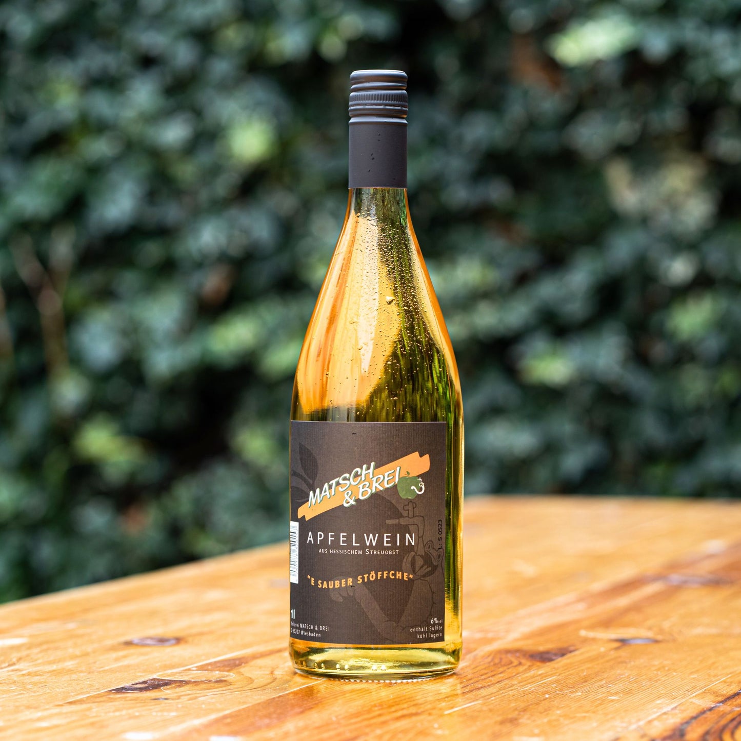 Gekühlte Matsch & Brei Apfelweinflasche auf einem Tisch in der Sonne